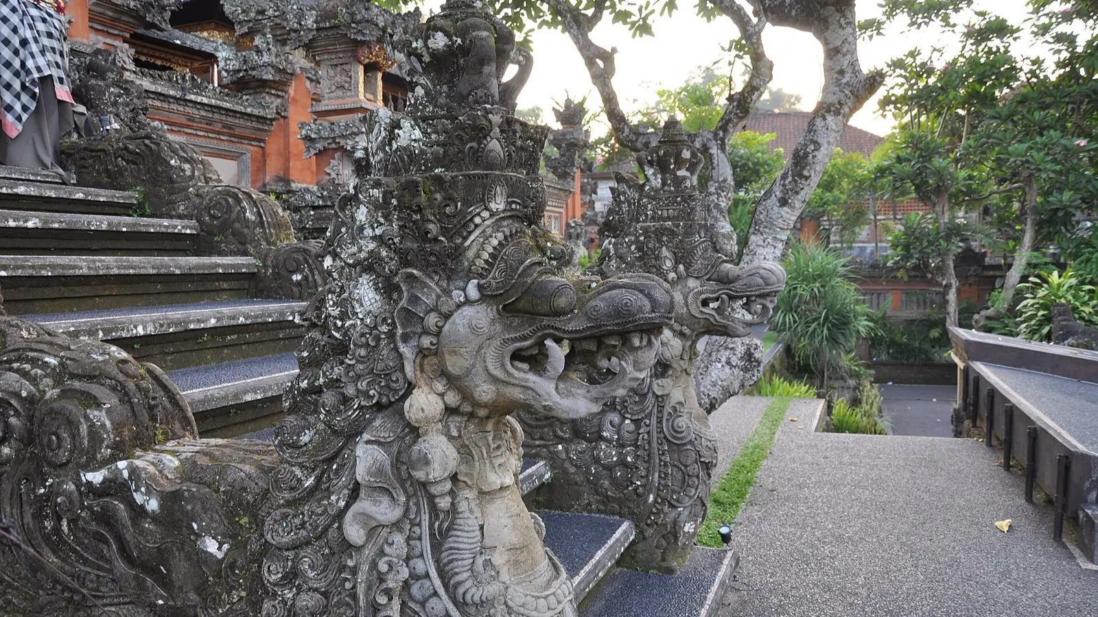 Pura Taman Saraswati temple flanked by blooming lotus ponds and intricate Balinese stone carvings