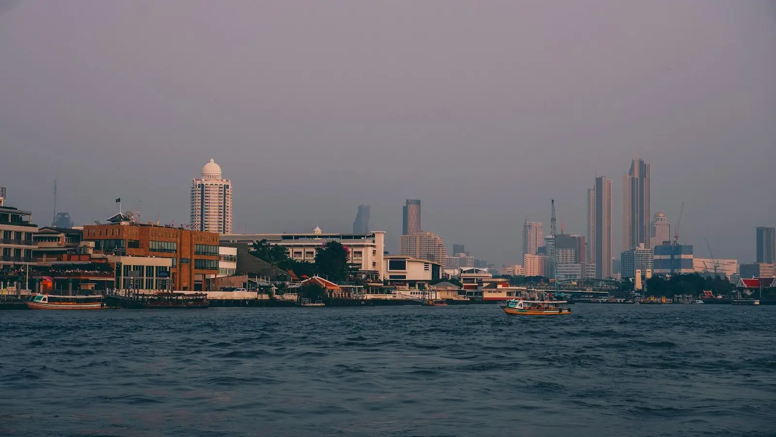 Bangkok modern riverside hotel towers and sparkling sunset skyline along the legendary Chao Phraya River