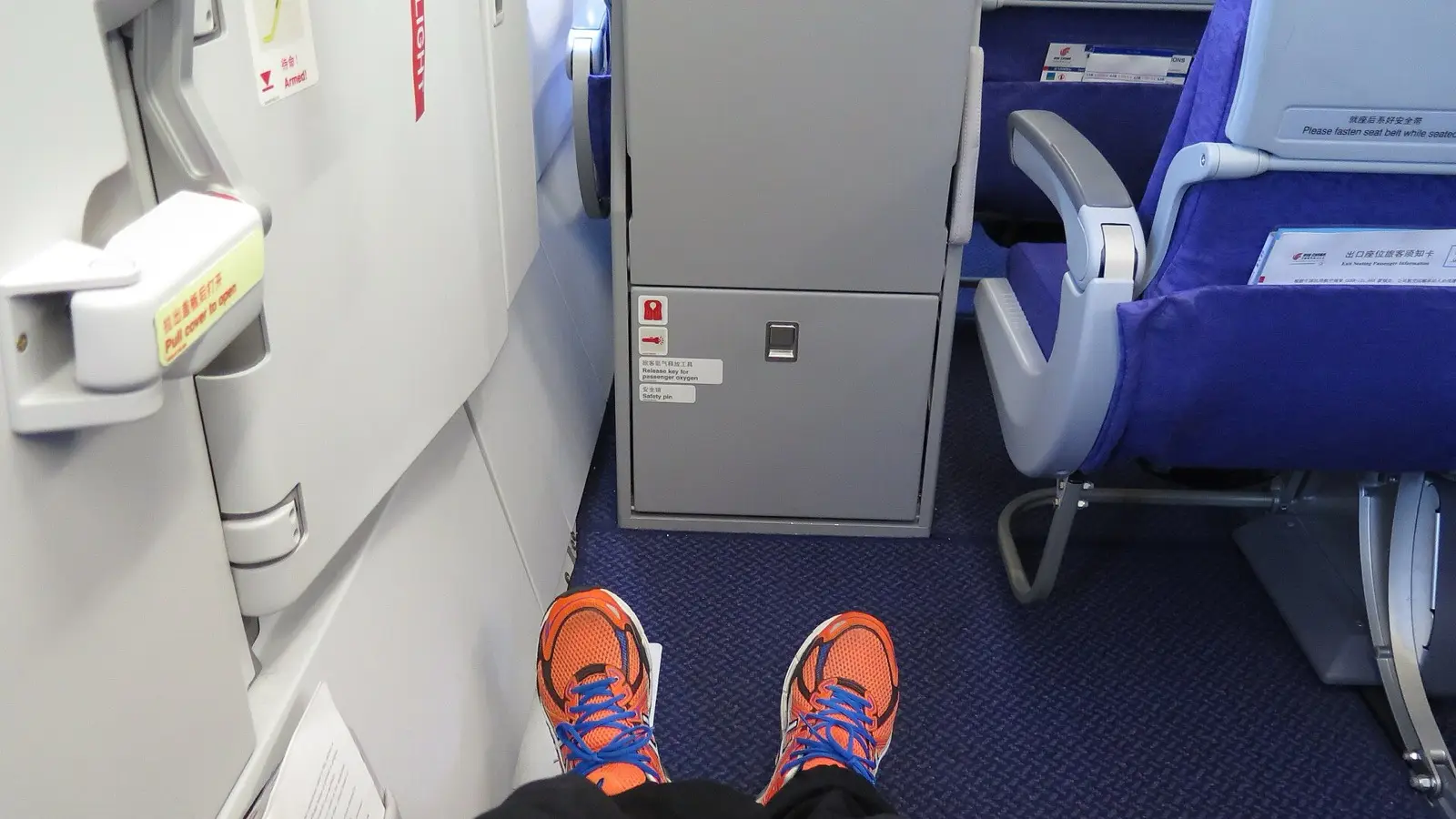 Emergency exit row seating providing generous legroom paired with fixed armrest dividers
