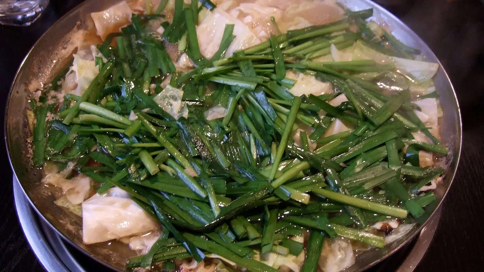 Hearty Hakata motsunabe hot pot simmered with plump offal, fresh garlic chives, and savory soy-miso broth