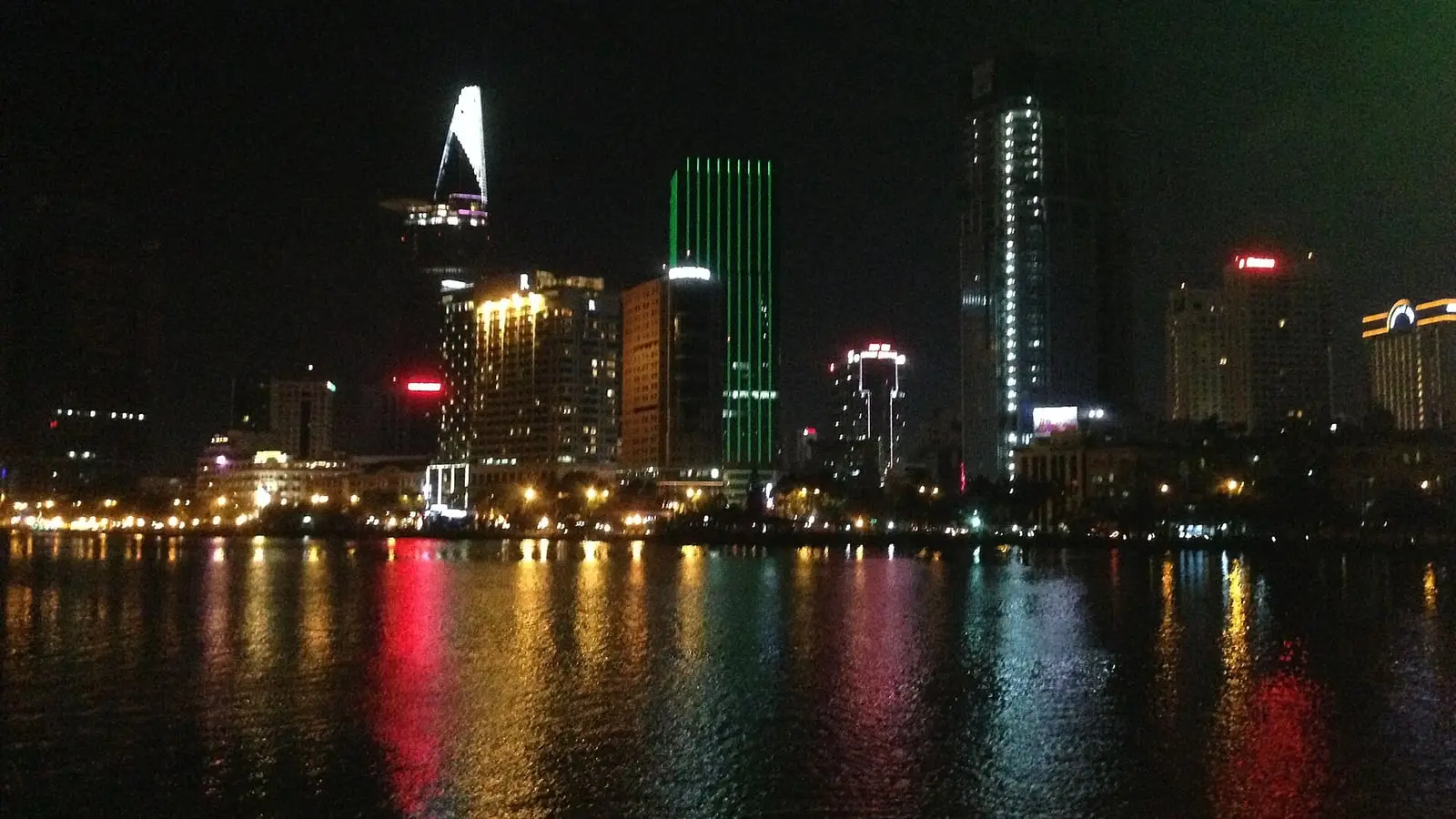 金融塔蓮花造型與摩天大樓群璀璨燈火倒映於西貢河面之胡志明市動感夜景