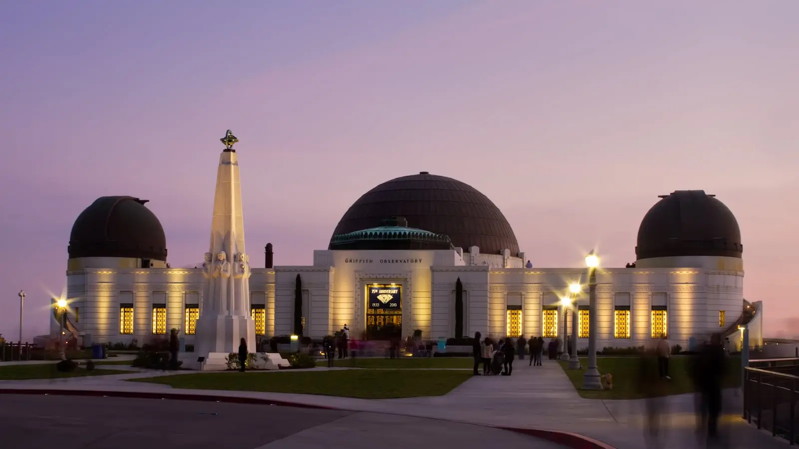 Endless grid of city lights stretching from Griffith Observatory toward the Pacific Ocean at twilight