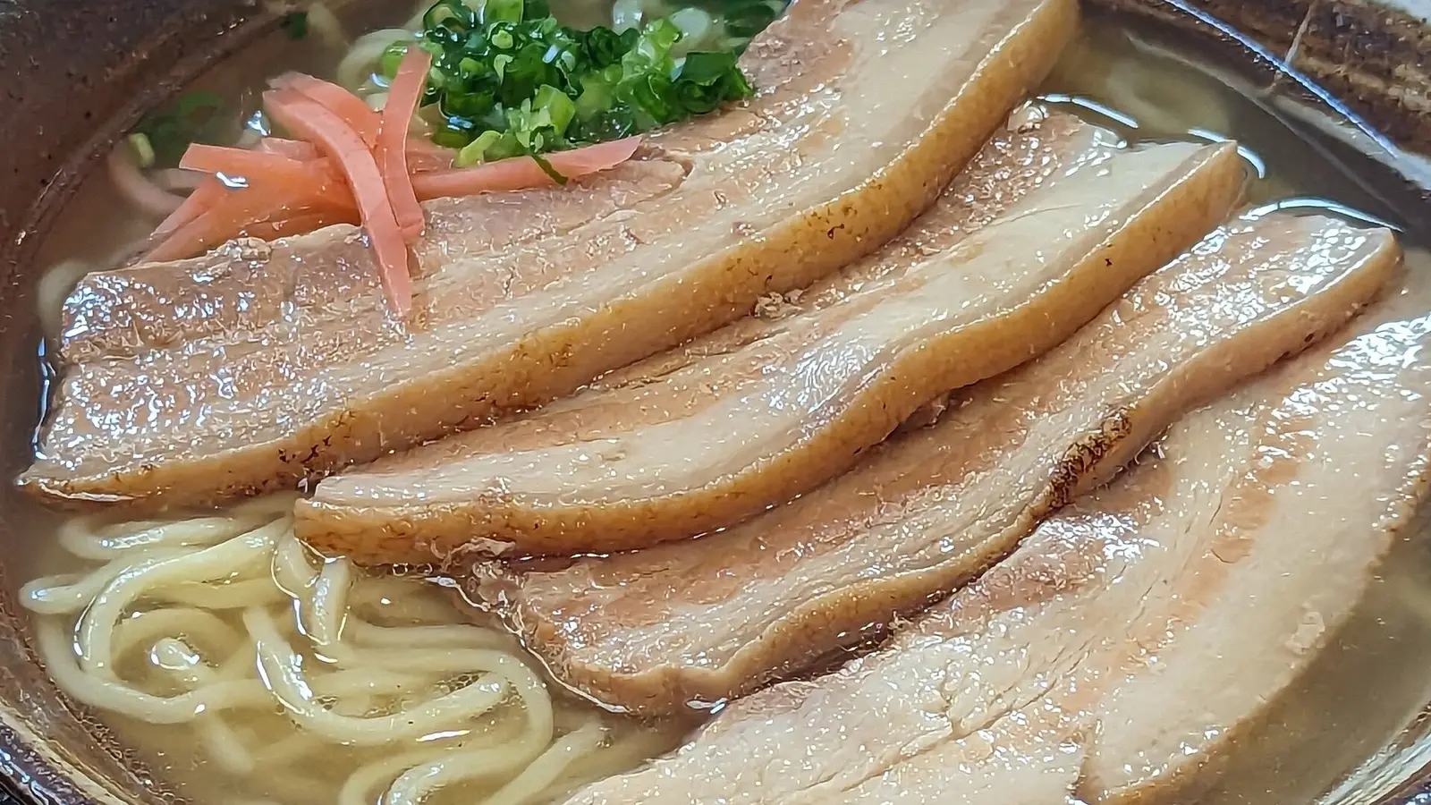 두툼한 소키(돼지갈비)와 붉은 생강을 얹은 따끈하고 깊은 맛의 전통 오키나와 소바