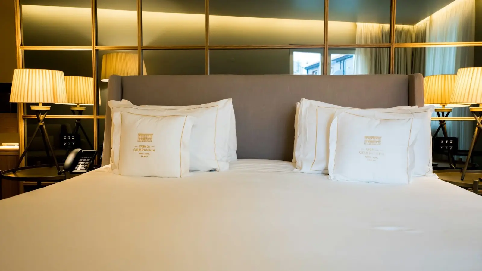 Sleek boutique hotel guest room featuring natural light windows, crisp linens, and minimalist timber accents