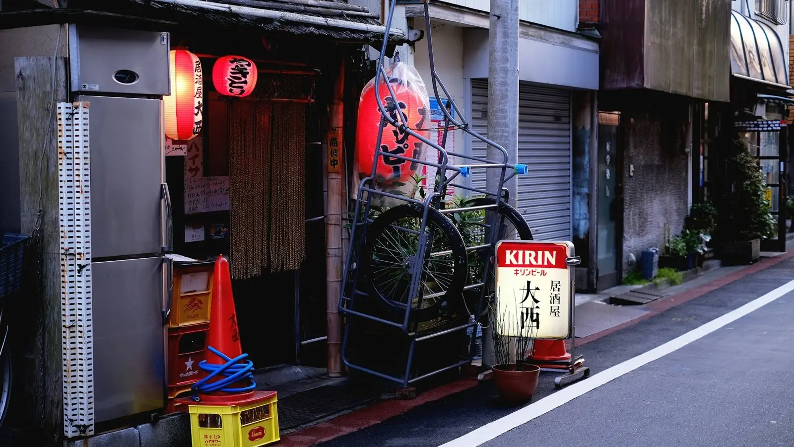 The entrance to Yanaka Ginza with traditional wooden shopfronts and local bicycles seen from Yuyake Dandan sunset steps