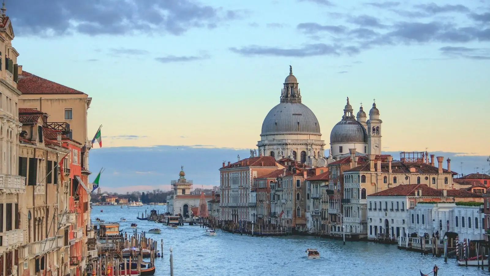 The distinctive silhouette of the leaning bell tower of San Martino mirroring across tranquil morning waters